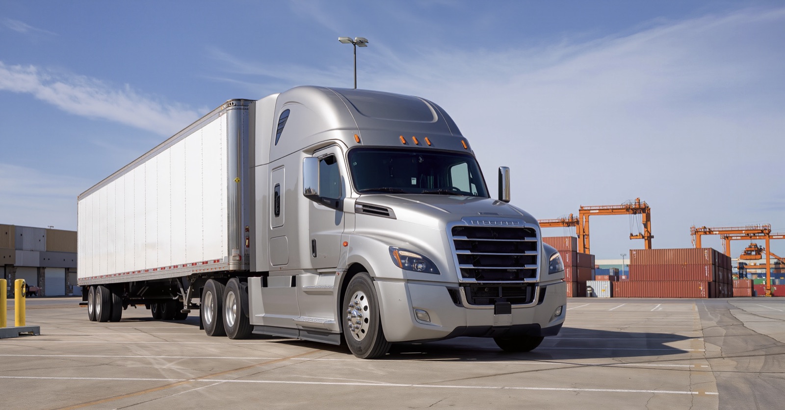 Ryan Logistics truck at a freight terminal with shipping containers